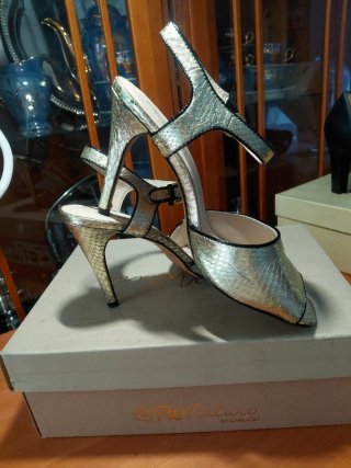 Zapatos de tacón dorados y el filo en negro