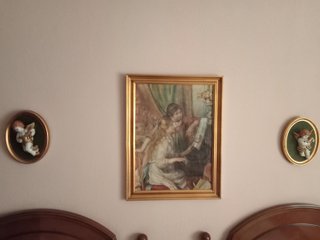 Angelitos de cerámica en marco dorado