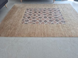 Alfombra de lana beige, de gran calidad.