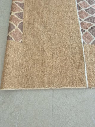 Alfombra de lana beige, de gran calidad.