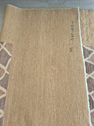 Alfombra de lana beige, de gran calidad.
