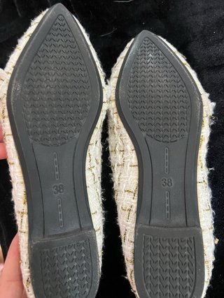 Zapatos planos blancos y dorados