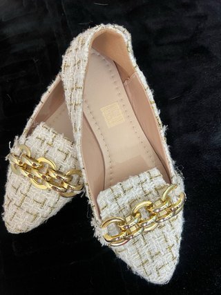Zapatos planos blancos y dorados