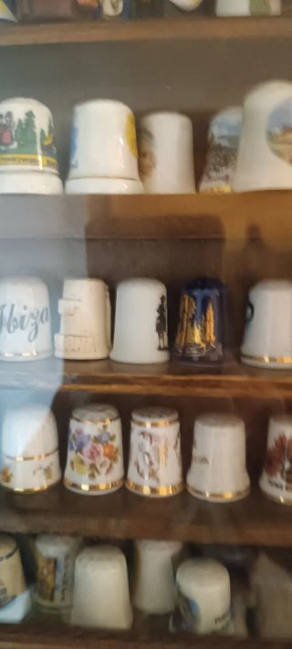 Vetrina in legno con collezione di ditali