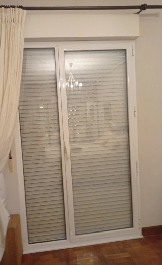 Puerta aluminio blanca con persiana