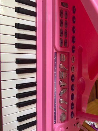 Piano de juguete rosa con micrófono y banqueta