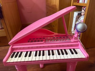 Piano de juguete rosa con micrófono y banqueta
