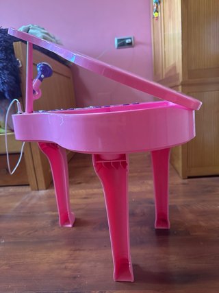 Piano de juguete rosa con micrófono y banqueta