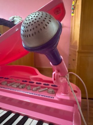 Piano de juguete rosa con micrófono y banqueta