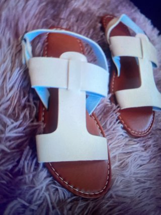 Sandalias planas blancas y marrones
