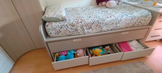 Cama nido beige y blanca con cajones.