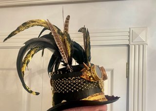 Sombrero de copa negro con adornos dorados