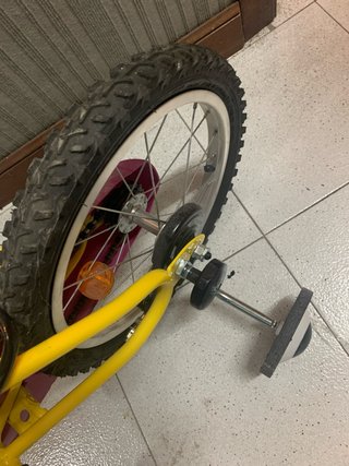Bicicleta infantil amarilla con ruedines