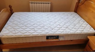 Cama de madera con colchón.