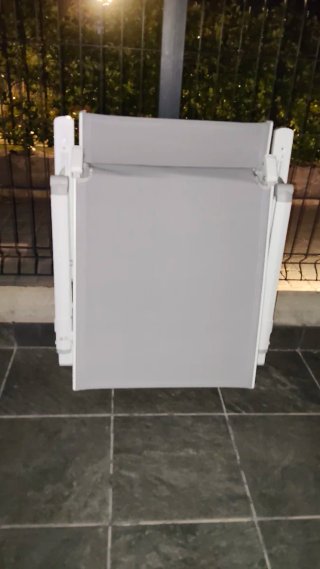 Tumbona plegable gris y blanca. En su caja