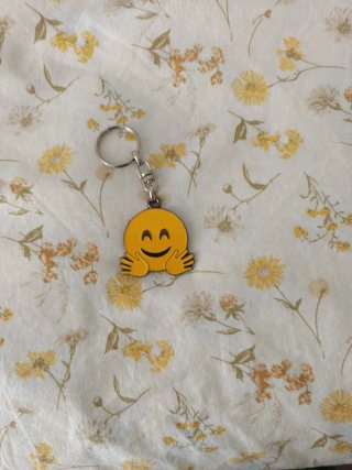 Llavero emoji sonriente con brazos
