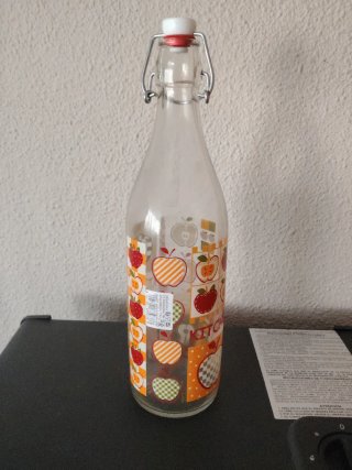 Botella de vidrio con diseño de manzanas