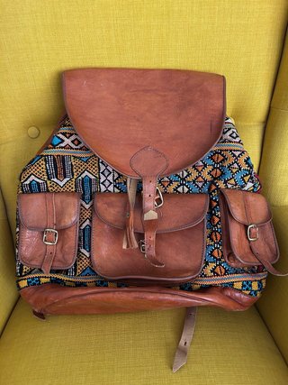 Mochila grande de cuero y tela con diseño étnico.