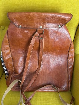 Mochila grande de cuero y tela con diseño étnico.