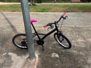Bicicleta negra con sillín y puños rosas