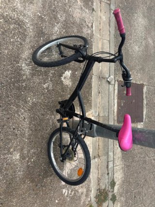 Bicicleta negra con sillín y puños rosas