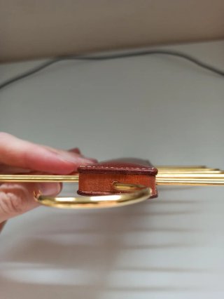 Colgador de corbatas de cuero con perchas doradas