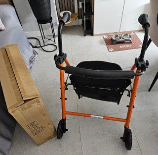 Andador naranja con asiento para movilidad reducid