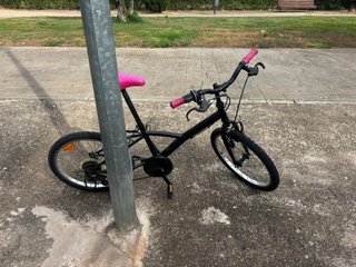 Bicicleta negra con sillín y puños rosas
