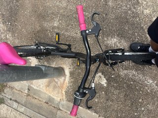 Bicicleta negra con sillín y puños rosas