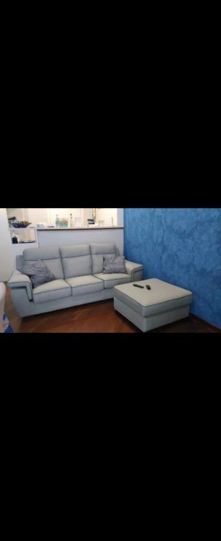Divano letto grigio con pouf