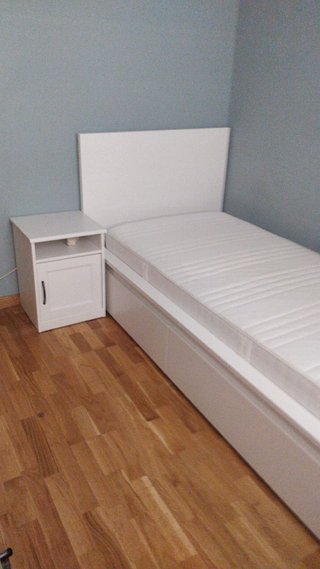 Cama individual blanca con colchón y mesita