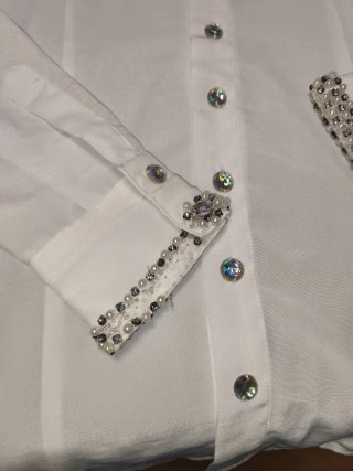 Traje de novio blanco y dorado.