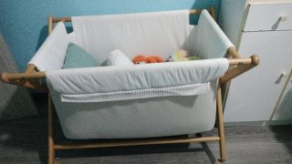 Mini cuna de madera con textiles