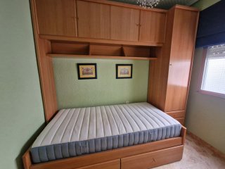 Mueble de madera con cama y armario