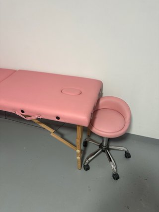 Camilla de masajes plegable en color rosa.