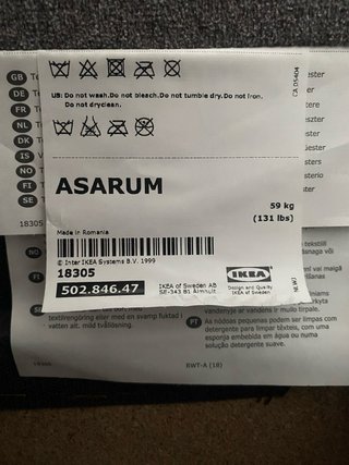 Sofá-cama IKEA ASARUM gris con cojines rojos