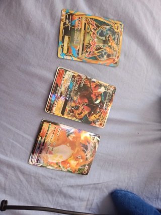 Trío de cartas Charizard VMAX Ex y GX