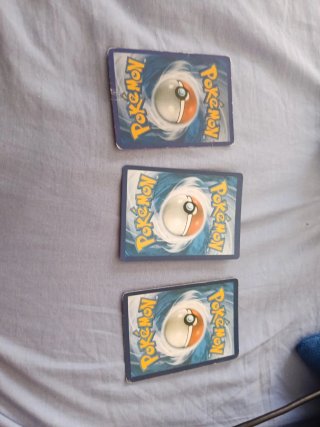 Trío de cartas Charizard VMAX Ex y GX