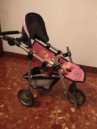Carrito de muñeca rosa con muñeca