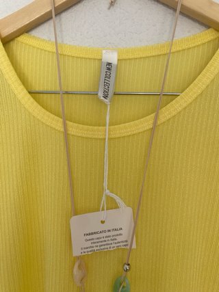 Camiseta amarilla y colgante