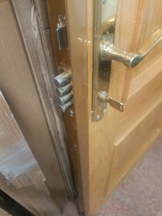Puerta de calle madera con cerradura de seguridad.