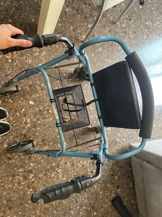 Andador con asiento, frenos y cesta.