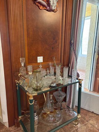Mueble bar verde con cristalería