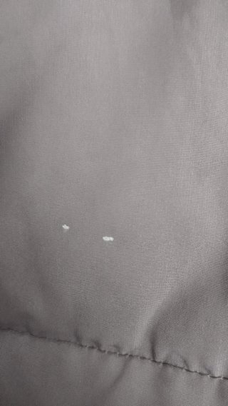 Abrigo Antea gris con capucha. Tiene dos manchas