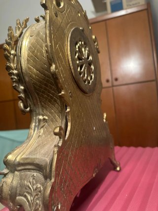 Reloj de sobremesa y candelabros de bronce.