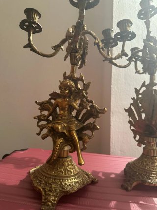 Reloj de sobremesa y candelabros de bronce.