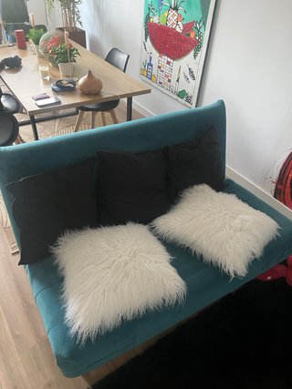 Sofá cama turquesa con cojines
