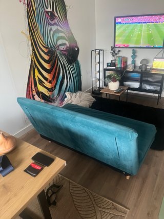 Sofá cama turquesa con cojines