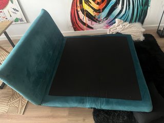 Sofá cama turquesa con cojines