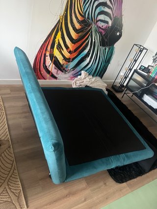 Sofá cama turquesa con cojines